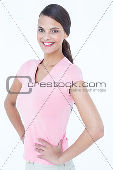 Happy brunette woman looking at camera with hands on hips