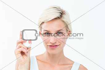 Pretty woman holding inhaler smiling at camera