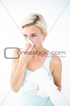 Sick woman blowing her nose