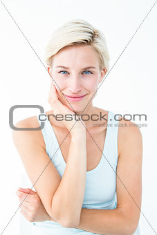 Happy woman smiling at camera with hand on cheek