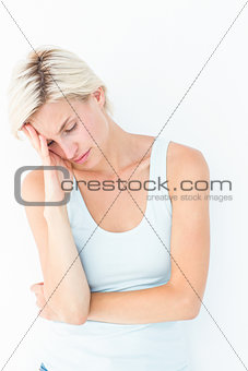 Depressed blonde woman with hand on temple