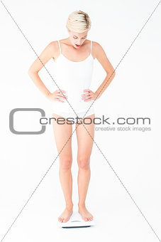 Blonde woman standing on weighing scales