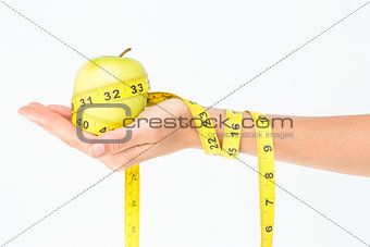 Woman holding an apple with tape measure