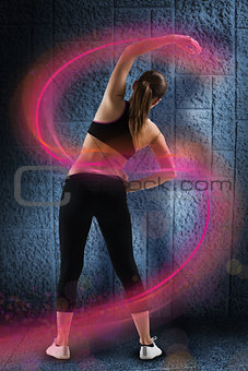 Composite image of fit brunette stretching rear view