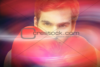 Composite image of fit man wearing red boxing gloves