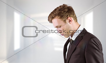 Composite image of young handsome businessman looking down