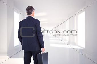 Composite image of businessman in suit looking through binoculars