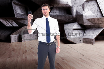 Composite image of serious businessman holding his phone