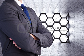Composite image of man in a suit with folded arms