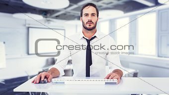 Composite image of focused businessman working on computer