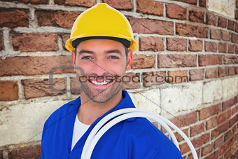 Composite image of electrician carrying wires over white background