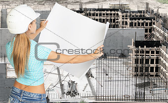Young woman in white hard hat holding paper