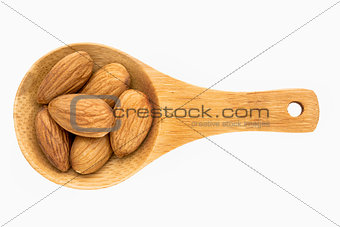 almond nuts on wooden spoon