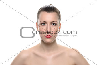 Strict bare woman staring at camera against white
