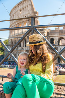 Mother and daughter sitting together at the Colosseum in Rome