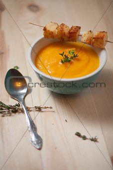 Bowl of pumpkin soup on  wood table