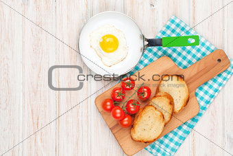 Healthy breakfast with fried egg, tomatoes and toasts