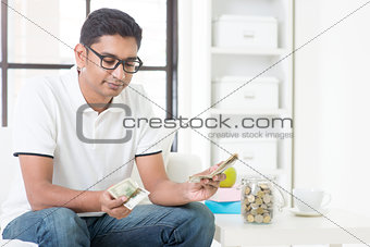 Sad Indian guy counting money