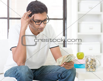 Stressed Indian guy counting money