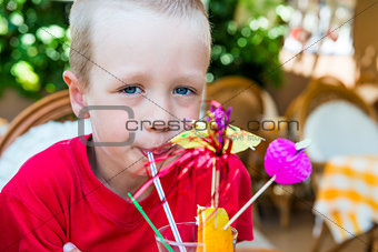 5 years old boy drinking a delicious fruit cocktail