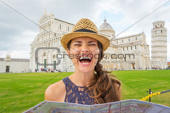 Laughing woman tourist holding map in near Leaning Tower of Pisa