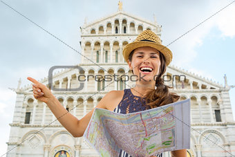Smiling woman tourist holding map and pointing in Pisa