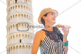 Smiling woman in profile with slice of pizza by Tower of Pisa