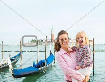 A happy mother holding her daughter in her arms in Venice