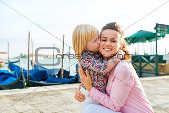 Daughter kissing mother who is kneeling down
