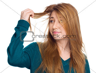 Young woman holding damaged long hair the hand and looking at split ends, isolated on white 