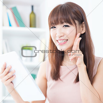 Asian girl using tablet showing peace hand sign