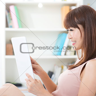 Asian female using touch screen tablet 