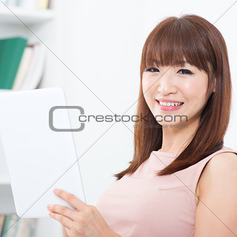 Asian woman using touch screen tablet 