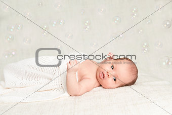 Laying newborn baby with bubbles