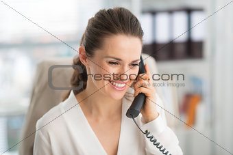 Elegant businesswoman on phone at work