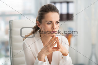 Pensive businesswoman with hands in steeple position