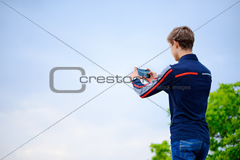 Young Man Taking Landscape Photograph Using Mobile Smart Phone