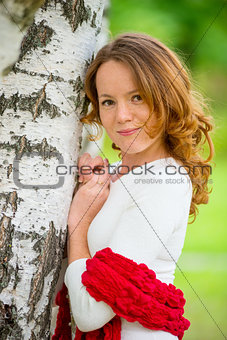 young beautiful girl with red hair in a birch