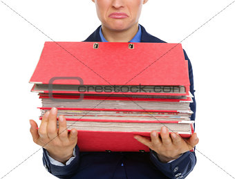 Closeup of upset businesswoman's hands holding stack of folders
