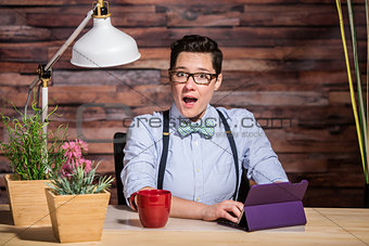 Excited Woman at Desk with Tablet