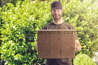 Cute guy with a happy grin making a delivery