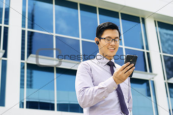 Businessman Talking Video Call On Mobile With Bluetooth Headset