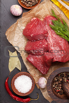Raw fillet beef steak and spices on stone board
