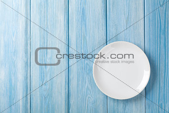 Empty plate on blue wooden background