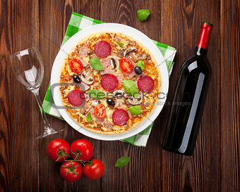 Italian pizza with pepperoni, tomatoes, olives, basil and red wi