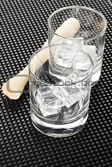 Cocktail glasses with ice and muddler