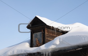 The roof of the old house covered with snow.