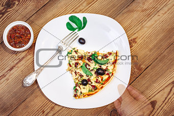 Slise of Pizza homemade with sauce on wooden background and arm