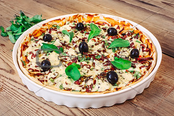 Pizza homemade with arugula on wooden background