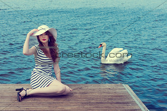romantic girl near a swan on lake